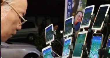 عجوز تايوانى يحمل 15 هاتفا بشواحنهم والسبب لعبة "بوكيمون".. فيديو وصور 