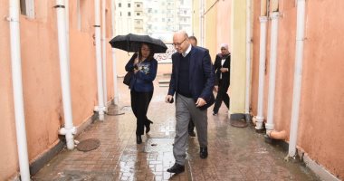 صور.. غادة والى تواجه سقوط الأمطار بمظلة خلال جولة مفاجئة بالإسكندرية