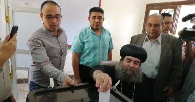 صور.. مطران أسيوط يدلى بصوته فى الاستفتاء على كرسى متحرك