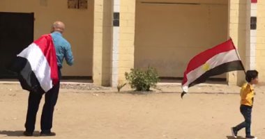 فيديو.. مشهد وطنى.. الجد فى إيده حفيدة بعلم مصر أثناء الاستفتاء بالرماية