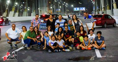 المصريون يلتقطون صورا تذكارية مع جمال كوبرى تحيا مصر ليلا