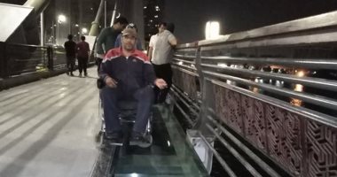 "رغم صعوبة الحركة".. "عادل" يشارك بصورته على الممشى الزجاجى بالكرسى المتحرك