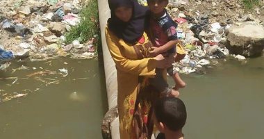 صور.. أهالى الفولى بالشرقية يعبرون الترعة فوق "ماسورة".. والمحافظ: ندرس الوضع