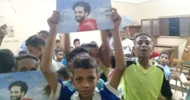 أطفال يرفعون صورا لمحمد صلاح خلال ندوة "لا للمخدرات" بأسوان