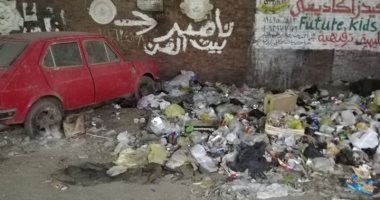 صور.. سيارة مركونة منذ فترة طويلة وسط القمامة بشارع لاشين فى المريوطية