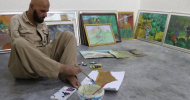 صور .. مواطن عراقى يهزم الإعاقة ويرسم 100 لوحة فنية بقدميه 