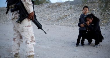 صورة بألف كلمة.. مهاجرة من جواتيمالا تصلى وتتوسل لضابط مكسيكى لدخول أمريكا