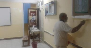 صور.. مدير مدرسة إعدادية بالقصير يطلى حوائط الفصول استعدادا لبدء الدراسة
