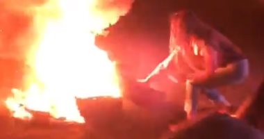 شاهد.. الفنانة نادين الراسى تشعل النيران فى إطار سيارة وسط مظاهرات لبنان