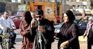 مصر فى صورة.. منتقبة تساعد كاهن كنيسة كفيف على عبور الطريق فى شبرا
