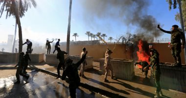 فيديو وصور.. غضب عارم فى المنطقة الخضراء.. قيادات الحشد تعتصم أمام سفارة أمريكا فى بغداد بعد استهداف عناصرها.. محتجون يضرمون النيران فى بوابات السفارة ويطالبون بطرد السفير.. ومراقبون: العراق يشهد حرب بالوكالة