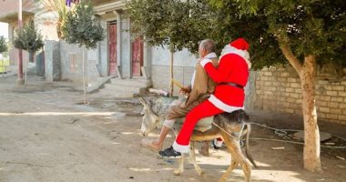 صور.. بابا نويل يوزع هدايا للأهالى والأطفال المرضى "على حمار" بإحدى قرى أسيوط