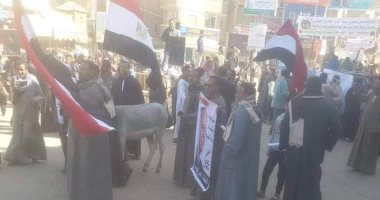 أهالى قوص بقنا يضعون صورة المقاول الهارب على حمار اثناء الاحتفال بعيد الشرطة