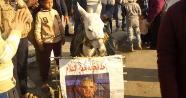 أهالى الدويقة يدهسون صور مذيعى الإخوان بالأحذية فى عيد الشرطة..فيديو وصور
