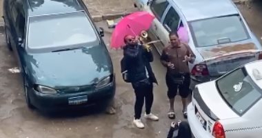 الحب لا يعرف العاصفة .. شاب يتحدى المطر بالعزف على "الساكسفون" أمام عمارة