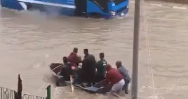 ماشيين عكس الاتجاه.. شباب يلجأون لمركب صيد للتنقل فى مياه الأمطار بمدينة نصر