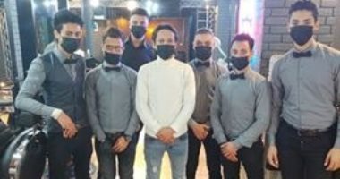 حافظا على صحة العامل والزبون.. عاملون بصالون حلاقة يرتدون الكمامات الطبية 
