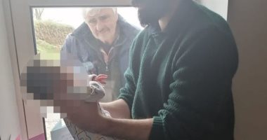 بسبب كورونا.. جد يلتقى بحفيده لأول مرة من وراء نافذة العزل.. صور