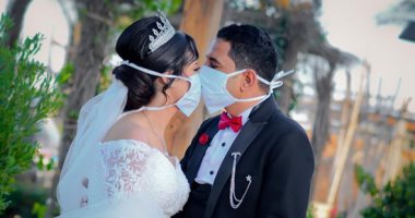 العروسان "أنطونيوس ونانسى" يواجهان كورونا بالمنيا بارتداء الكمامة وحمل الكلور