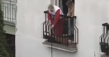 "في زمن كورونا" مسنة تنزل كلبها من شرفة منزلها لأخذ نزهة في الهواء.. فيديو