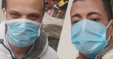 قارئ يشارك صورته بالكمامة مع زميله بالعمل فى حى وسط البلد