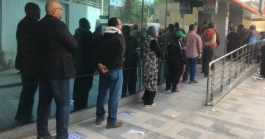 أيدى فى ايدك نواجه كورونا.. متطوعون يضعوا مقاعد وعلامات لتنظيم صرف المعاش  