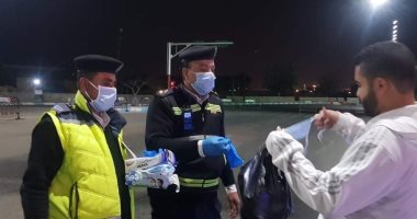 ضابط شرطة بمرور السويس يوزع كمامات وجونتات على المواطنين خوفًا من كورونا.. صور