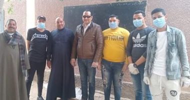 شباب قرية بنى حرام بالمنيا يطهرون الشوارع ويوزعون الكمامات على الأهالى