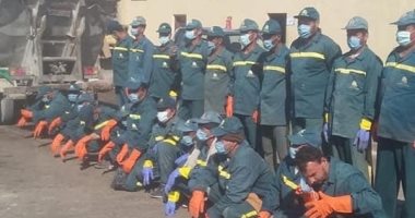 عمال النظافة بالكمامات خلال تطهير شوارع العريش