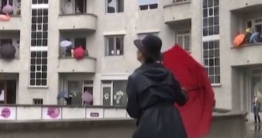 "ارقص تحت المطر".. سكان سويسرا يقضون ساعات الحظر بطريقة مبهجة من البلكونات