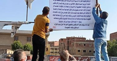 تعليق بنرات التوعية بلبس الكمامة بموقف بنها ومسطرد بشبين القناطر.. صور