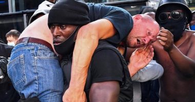 الكشف عن تفاصيل صورة حمل متظاهر أسود لآخر أبيض فى مظاهرات لندن