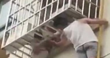 موقف بطولى من رجل صينى أنقذ طفلة تعلقت رأسها فى شرفة منزل.. شاهد عمل إيه 