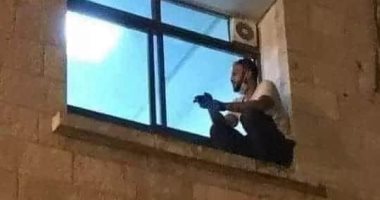 صورة متداولة لشاب يصعد لنافذة مستشفى عزل ليطمئن على والدته.. اعرف تفاصيلها