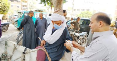 قوات التأمين تساعد مسنا على الإدلاء بصوته على كرسى متحرك فى طوخ