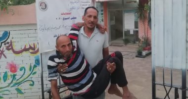 مواطن يحمل آخر من ذوى الهمم وسيدة تأتى بالعكاز للتصويت فى الإسماعيلية 