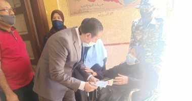 رئيس لجنة يخرج لمساعدة عجوز فى الإدلاء بصوتها فى الإسكندرية.. صور
