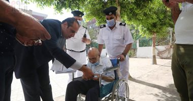 رئيس لجنة فرعية بالعمرانية يساعد "قعيد" للإدلاء بصوته بانتخابات النواب.. صور