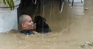 شخص يخاطر بحياته لإنقاذ كلب وسط مياه الفيضان فى الفلبين.. فيديو وصور