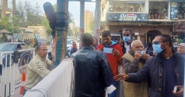 الشرطة توزع الكمامات على الناخبين فى لجان بنى سويف.. صور