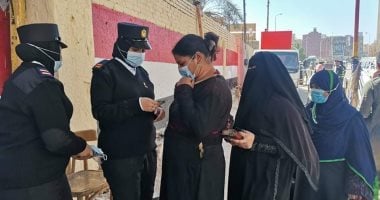الشرطة توزع الكمامات على الناخبين فى لجان أسوان.. صور 