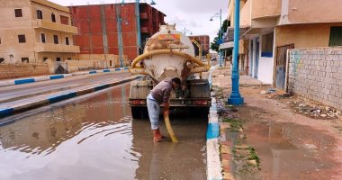 استمرار رفع تجمعات مياه الأمطار بالطريق الدولى فى مرسى مطروح.. صور