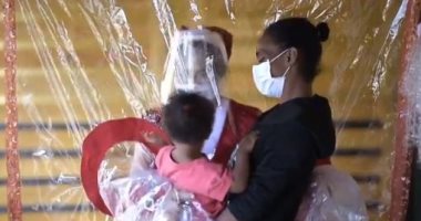 برازيلية ترتدى زى بابا نويل وتعانق الأطفال خلف الحواجز بسبب كورونا.. فيديو