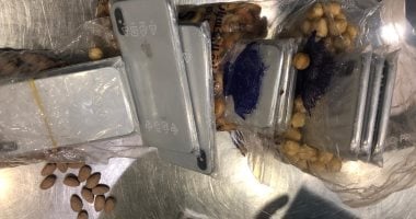 جمارك مطار القاهرة تضبط راكبين حاولا تهريب هواتف داخل أكياس "مكسرات"..صور