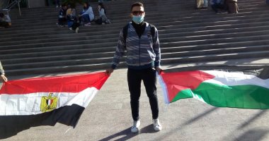 شاب مصري من أمام برج القاهرة يحمل العلمين المصري والفلسطينى.. صور