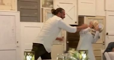 هزار تقيل.. عريس يقذف عروسه بالتورتة أثناء حفل زفافهما بأمريكا.. فيديو وصور