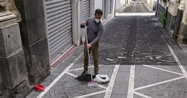 إيطاليون ينظفون الشوارع والمنازل من الرماد الناتج عن بركان إتنا.. صور