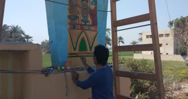 "الأسد" فنان قنائى يحول القرى إلى متاحف مفتوحة عن طريق الرسم بقنا