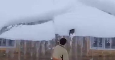شاب يتعرض لموقف طريف خلال إزالة الثلوج من سطح منزله.. فيديو وصور