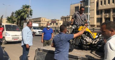 حى الدقى يصادر موتوسيكلات أمام جامعة القاهرة تركها أصحابها أعلى الرصيف.. صور